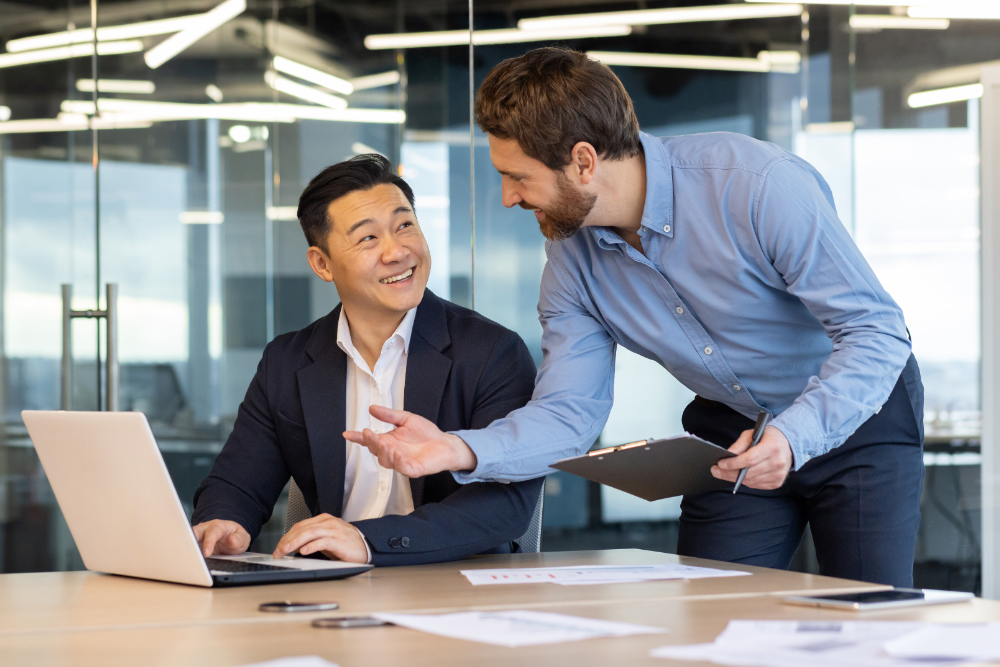 Two male colleagues working in a modern office setting. 